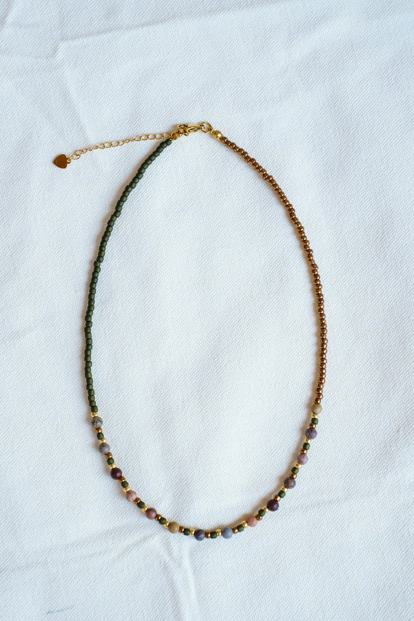 Handmade pink zebra jasper necklace with green and gold seed beads and 18k gold PVD findings. Necklace measures approximately 16" with a 2" extender.