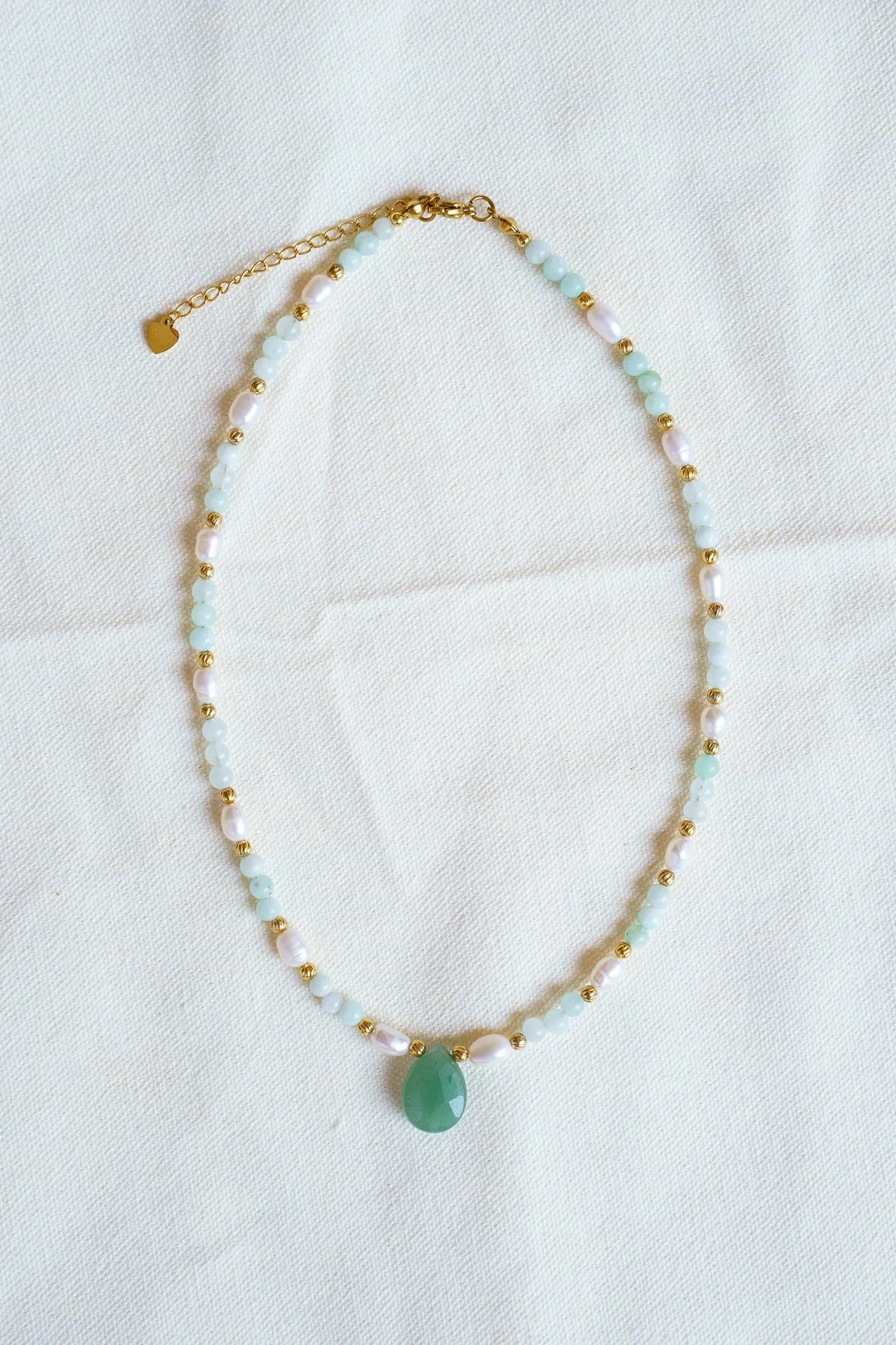 Handmade necklace with amazonite beads, freshwater pearls, and a green aventurine pendant with gold seed beads and 18k gold PVD findings. Necklace measures approximately 15" with a 2" extender.
