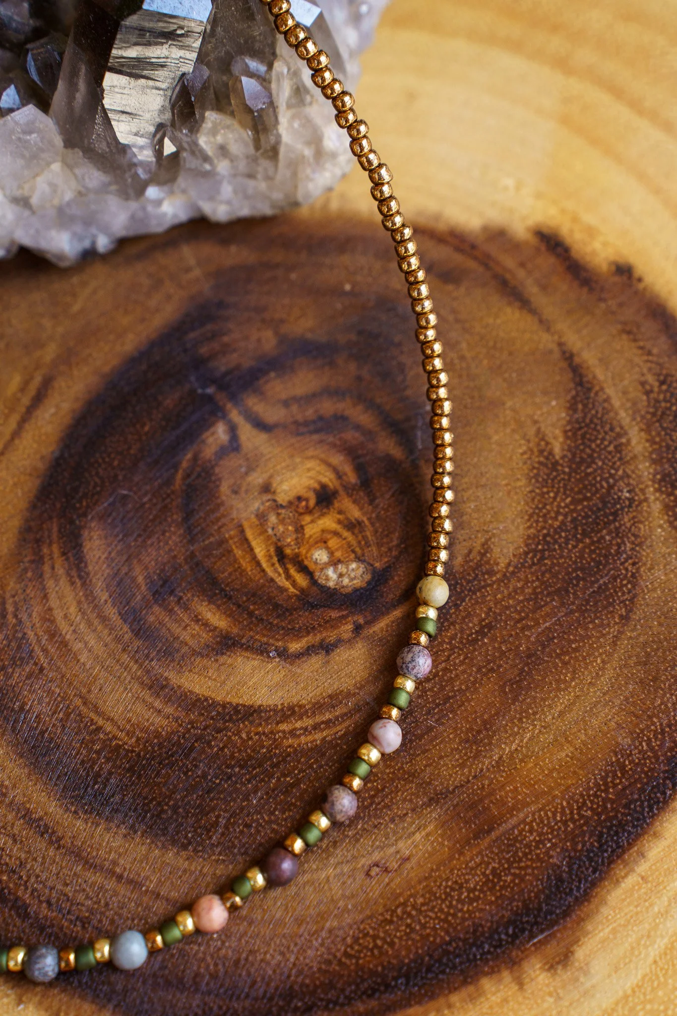 Handmade pink zebra jasper necklace with green and gold seed beads and 18k gold PVD findings. Necklace measures approximately 16" with a 2" extender.