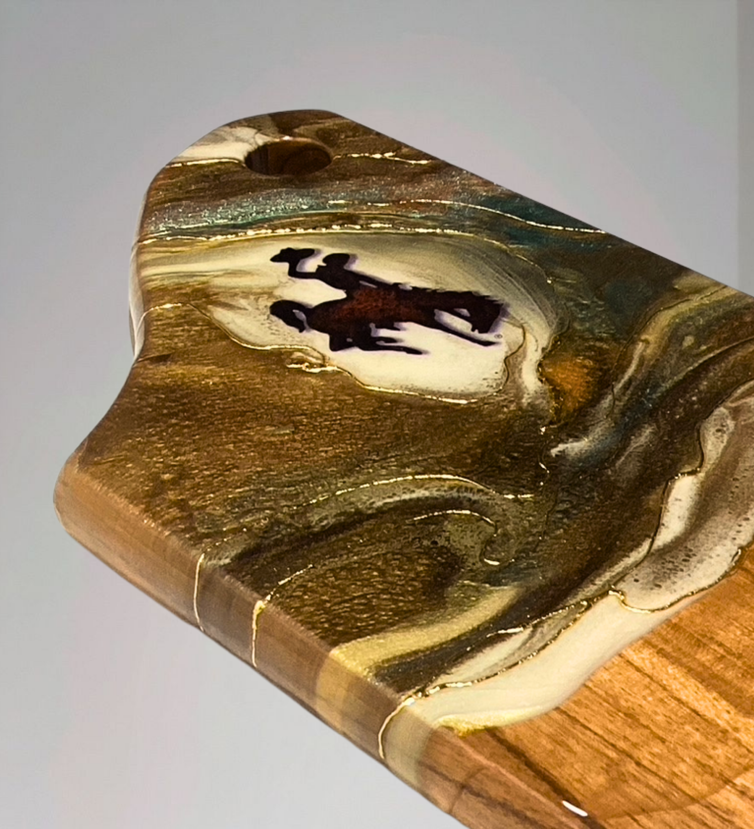 Handmade acacia wood charcuterie board with bucking horse design, resin art, and 24K gold accents inspired by Wyoming western heritage