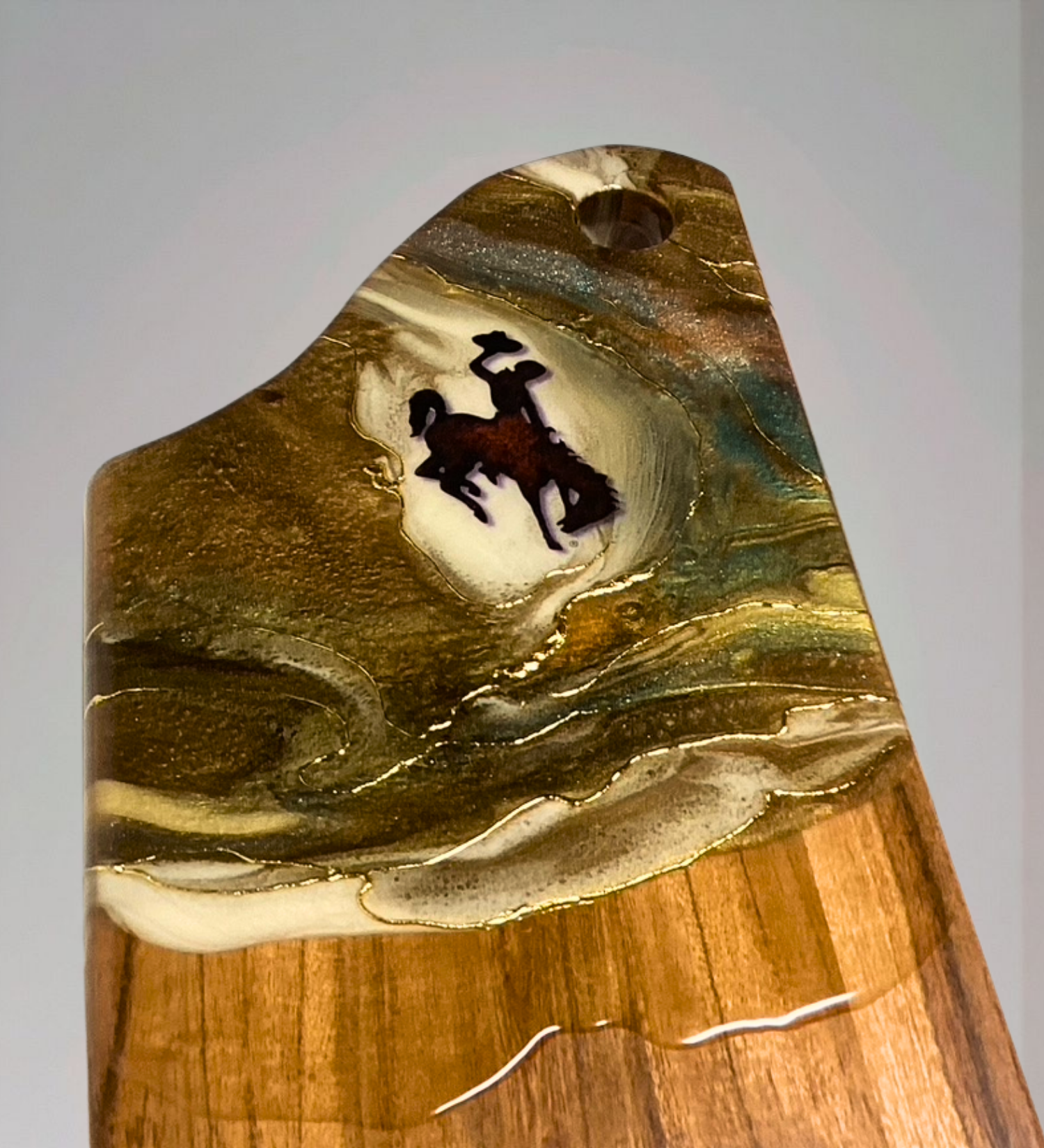 Handmade acacia wood charcuterie board with bucking horse design, resin art, and 24K gold accents inspired by Wyoming western heritage