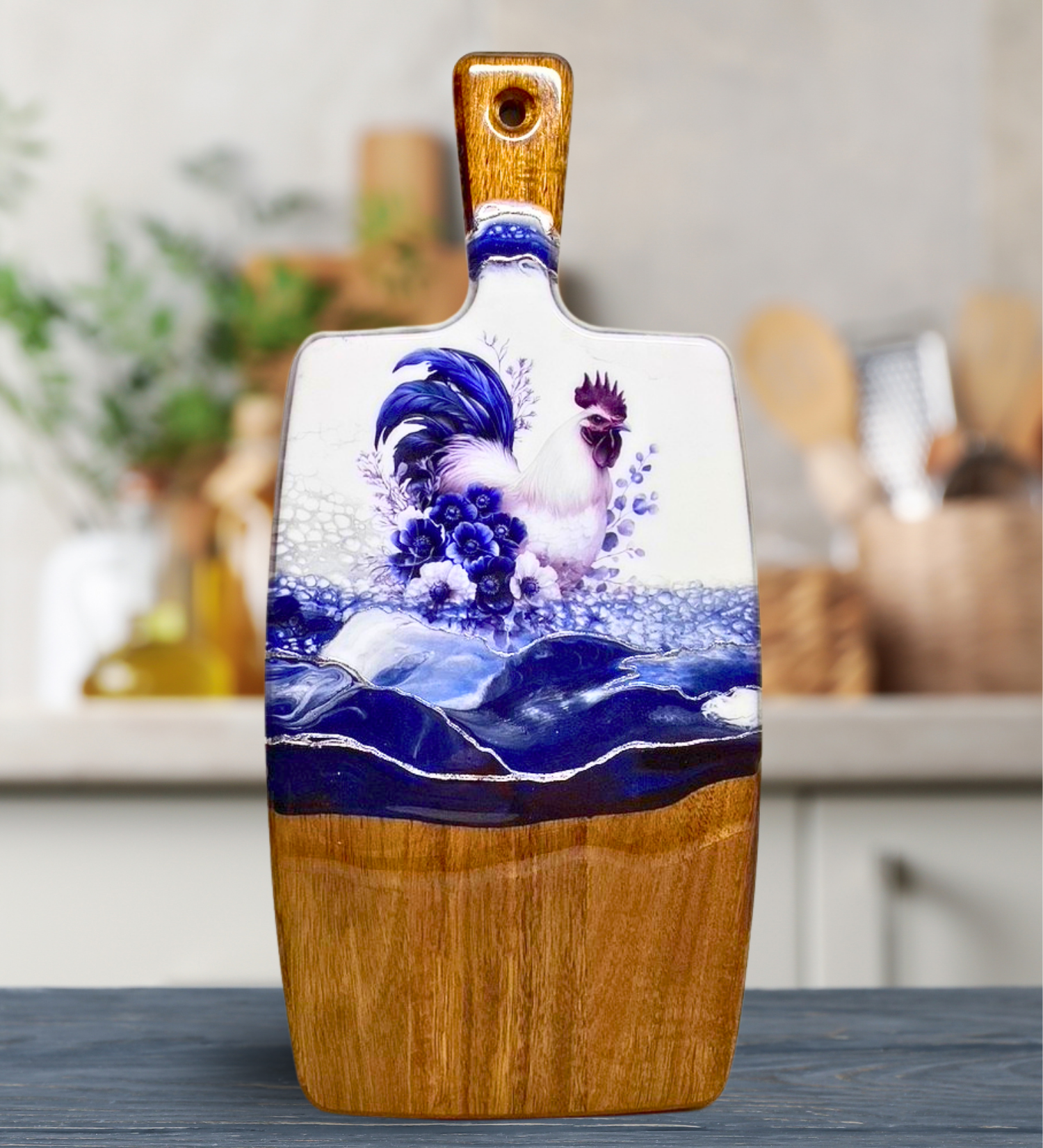 Handmade farmhouse charcuterie board with blue rooster artwork and flowing blue resin accents on natural hardwood.