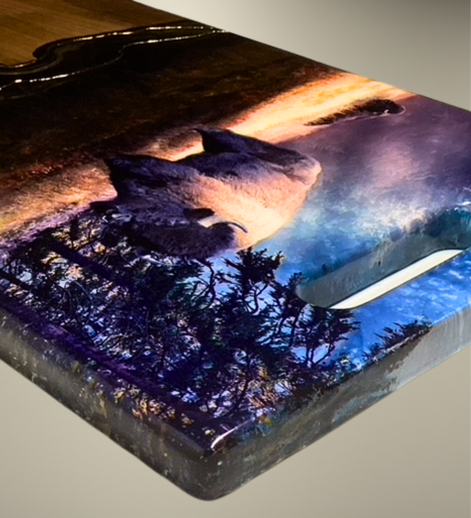 One-of-a-kind walnut charcuterie board featuring a bison prairie scene with hand-painted resin artwork and 24K gold accents. Functional Western art for entertaining.