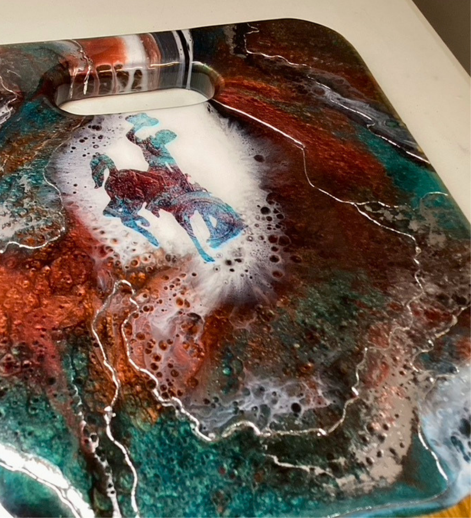 Handmade teak charcuterie board with Wyoming Cowboy design, copper and teal resin artwork, and 24K gold accents