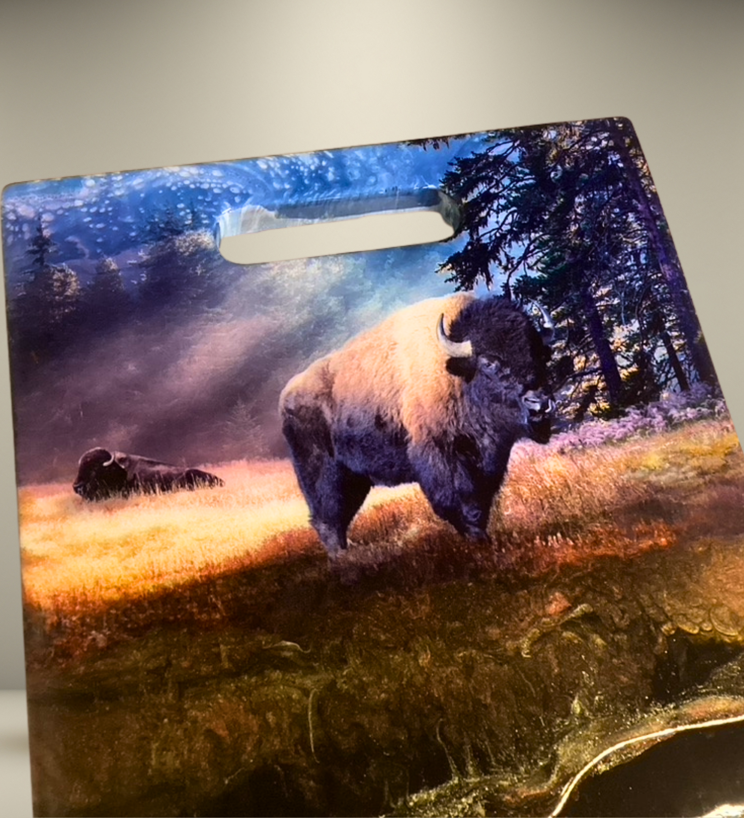 One-of-a-kind walnut charcuterie board featuring a bison prairie scene with hand-painted resin artwork and 24K gold accents. Functional Western art for entertaining.