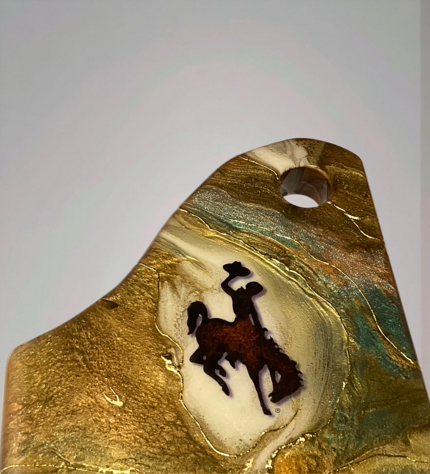 Handmade acacia wood charcuterie board with bucking horse design, resin art, and 24K gold accents inspired by Wyoming western heritage