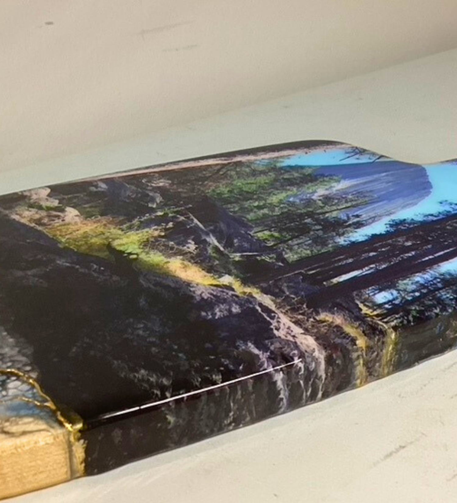 Handcrafted devils tower Wyoming charcuterie board with black and blue resin artwork on maple hardwood serving board.