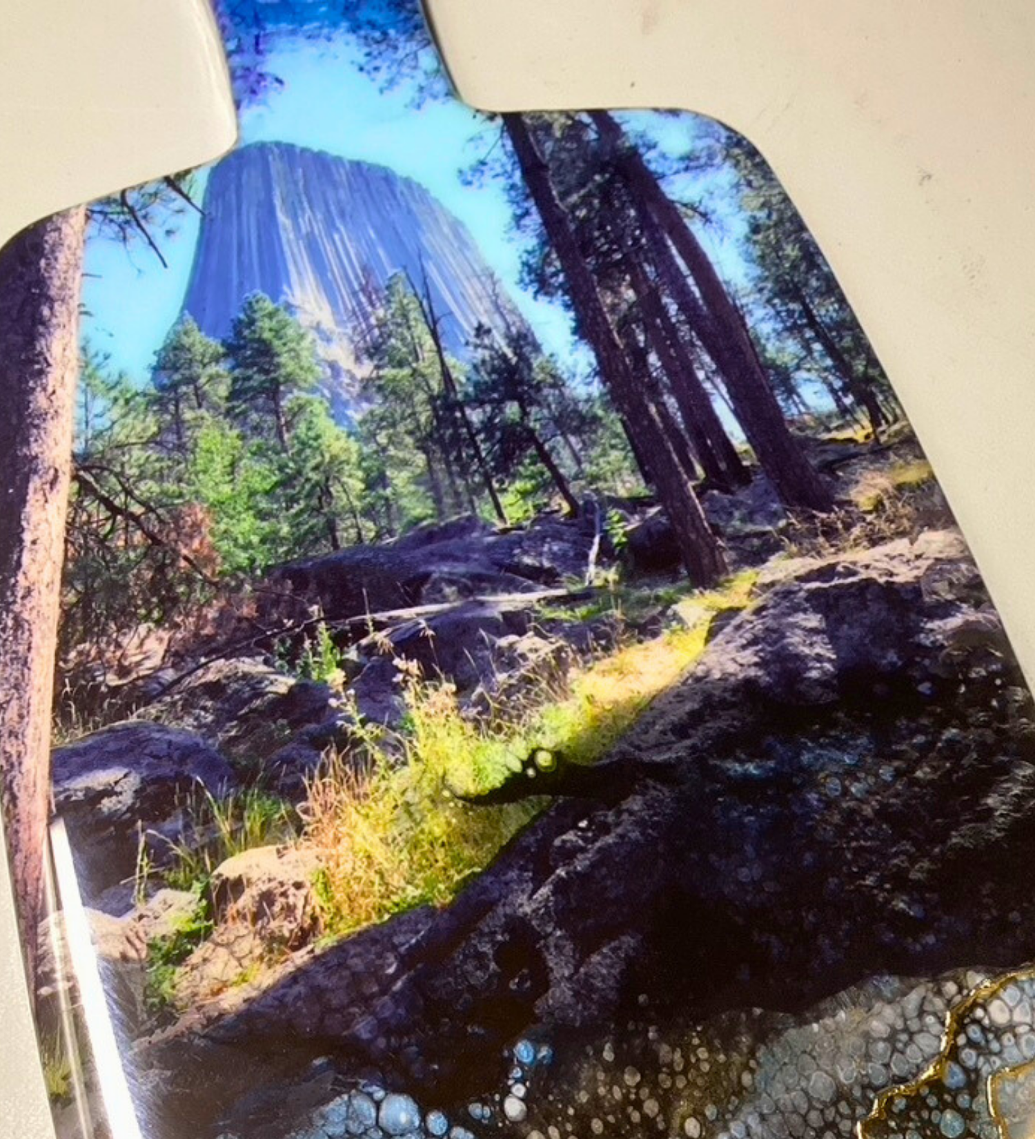 Handcrafted devils tower Wyoming charcuterie board with black and blue resin artwork on maple hardwood serving board.