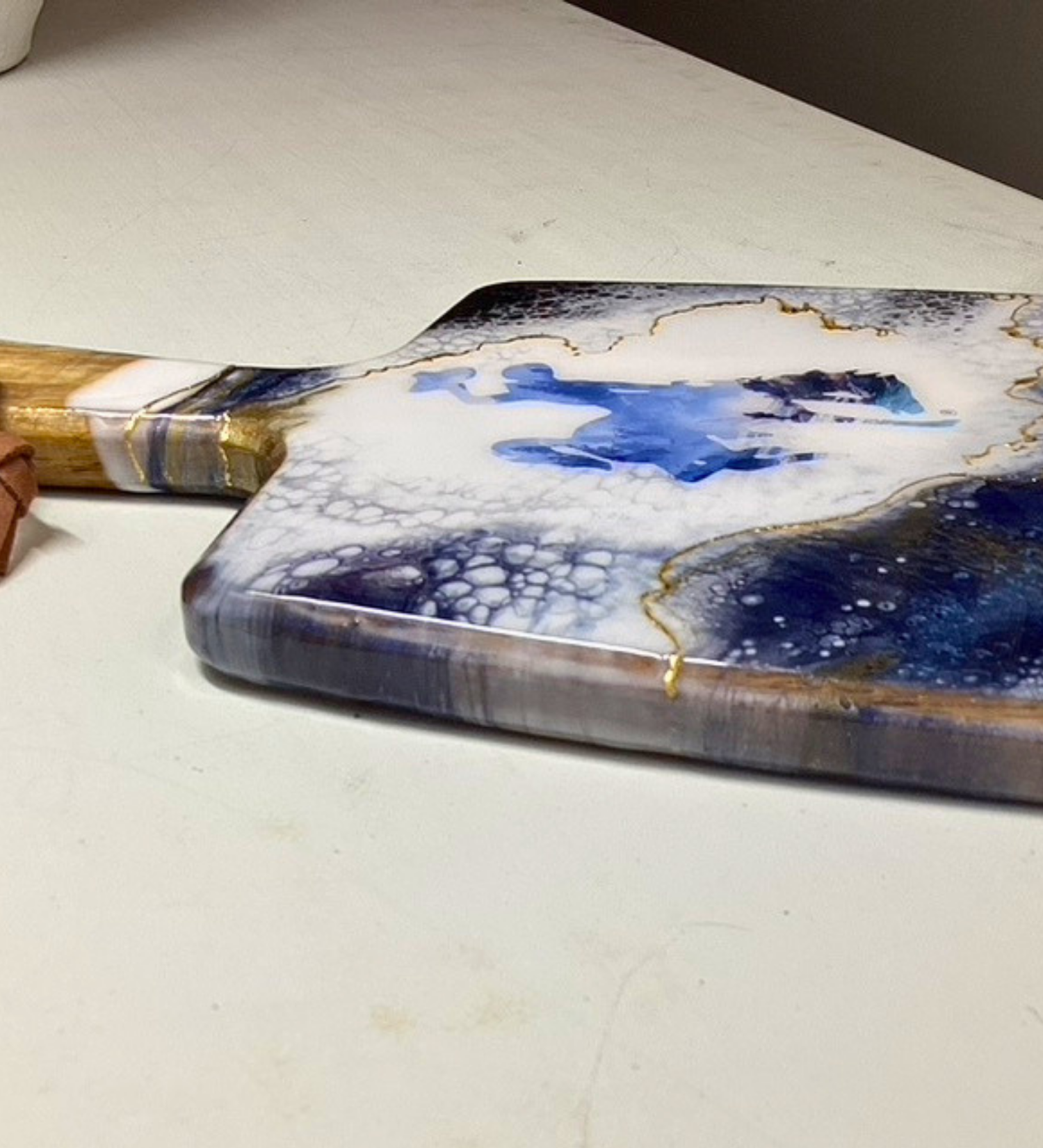 Handmade Wyoming charcuterie board with fly fisherman scene, resin art, and 24K gold accents on acacia wood