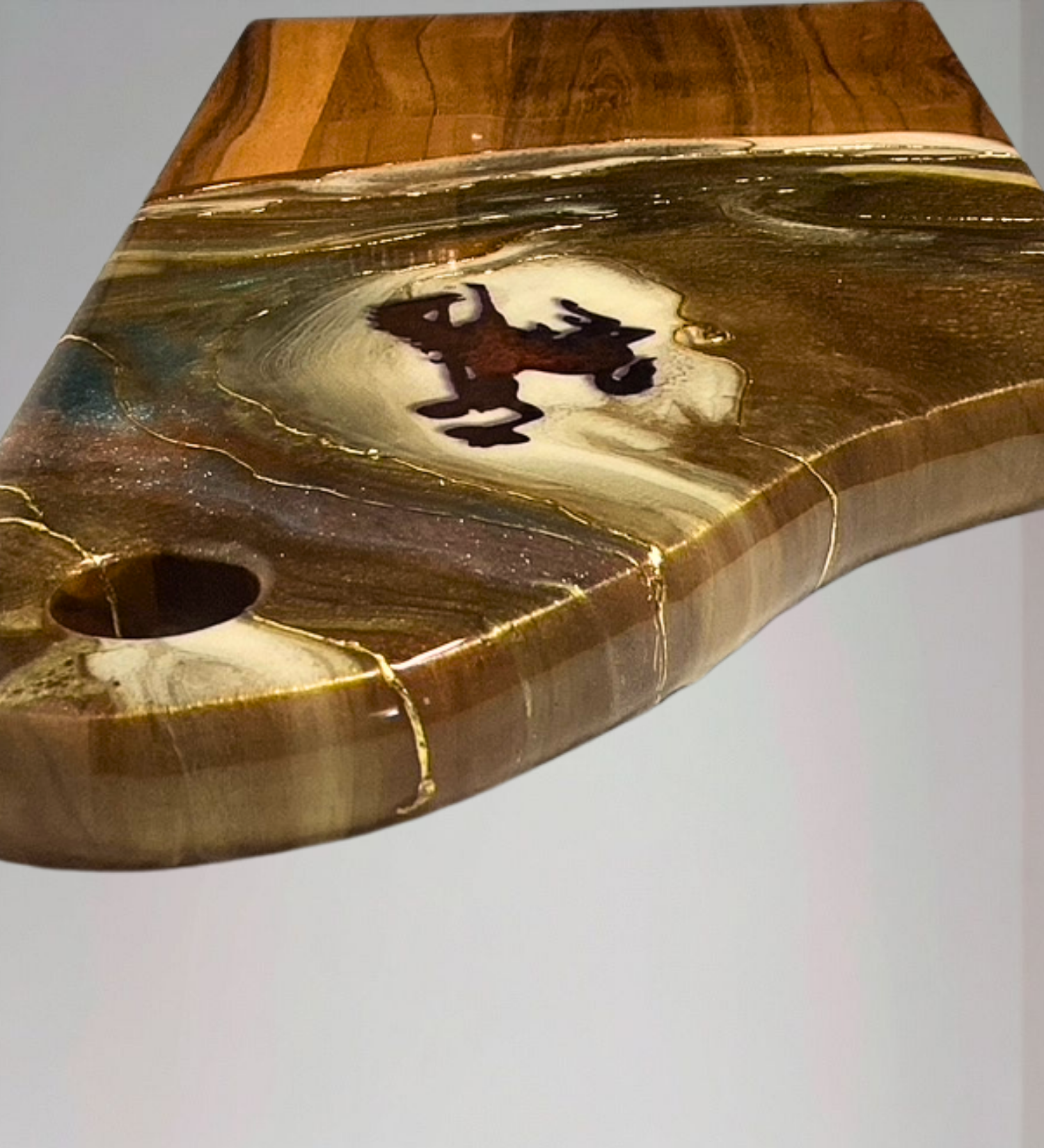 Handmade acacia wood charcuterie board with bucking horse design, resin art, and 24K gold accents inspired by Wyoming western heritage