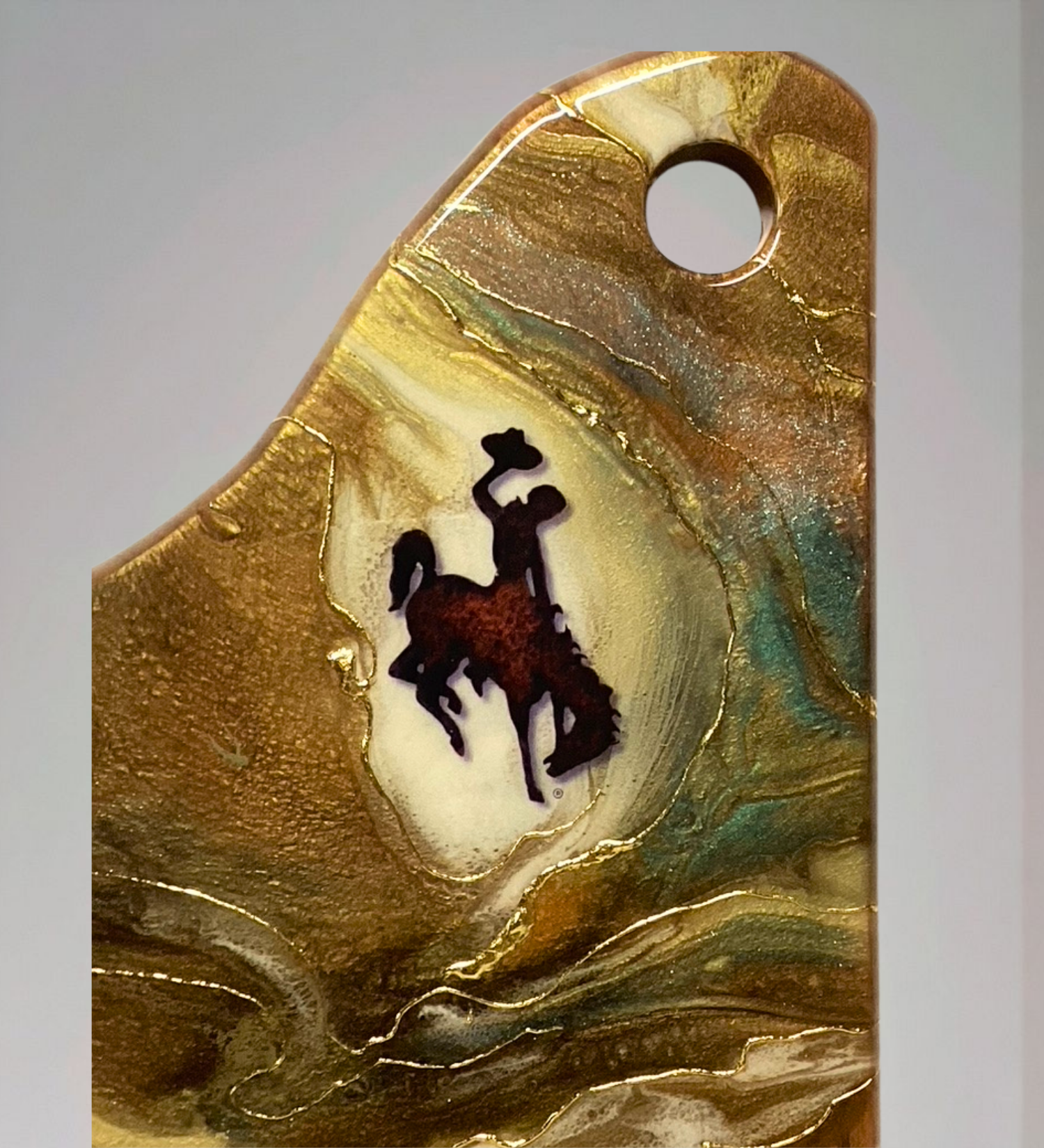 Handmade acacia wood charcuterie board with bucking horse design, resin art, and 24K gold accents inspired by Wyoming western heritage