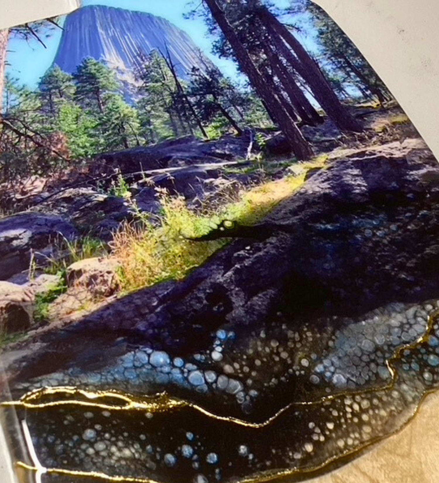 Handcrafted devils tower Wyoming charcuterie board with black and blue resin artwork on maple hardwood serving board.