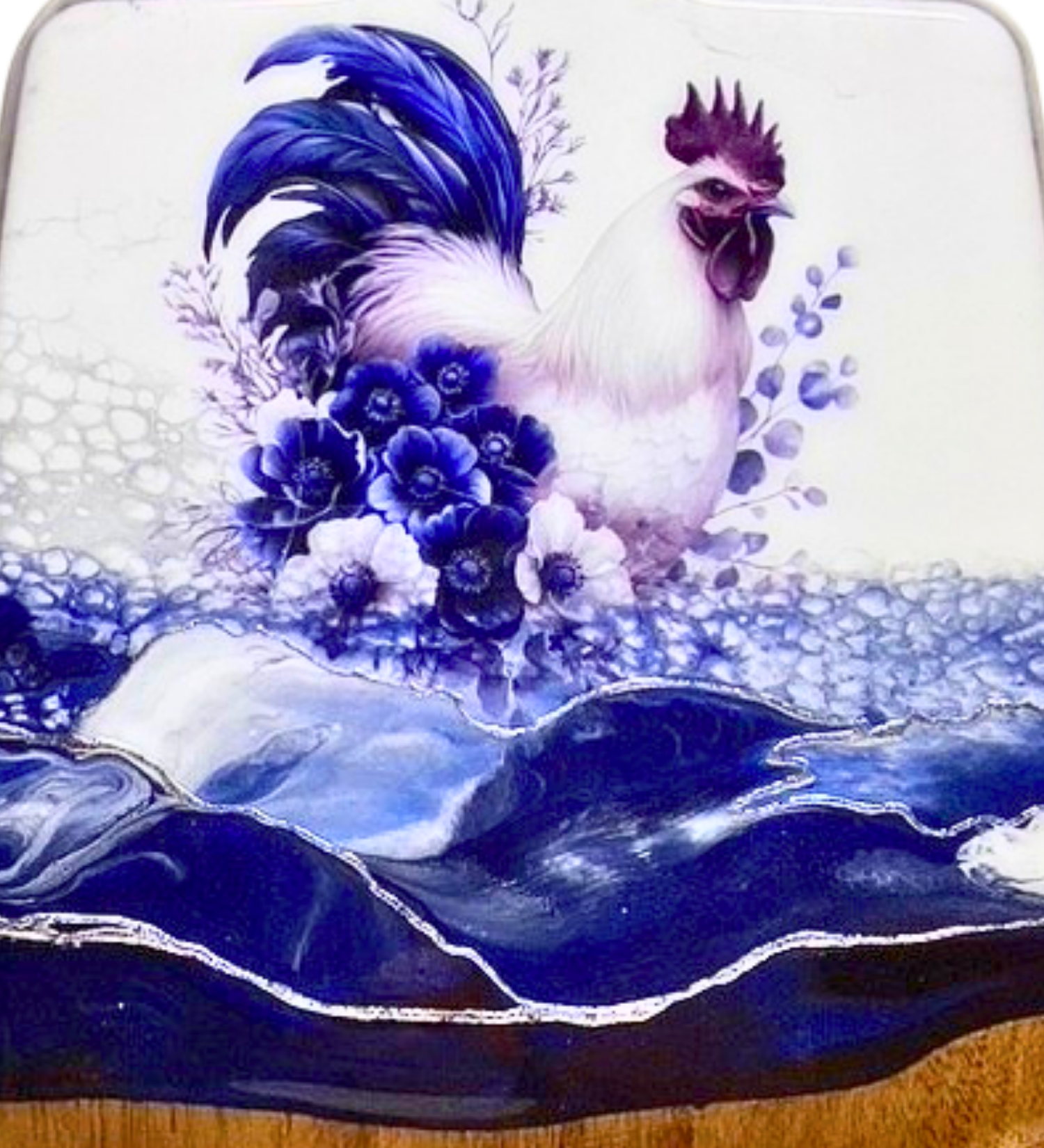 Handmade farmhouse charcuterie board with blue rooster artwork and flowing blue resin accents on natural hardwood.