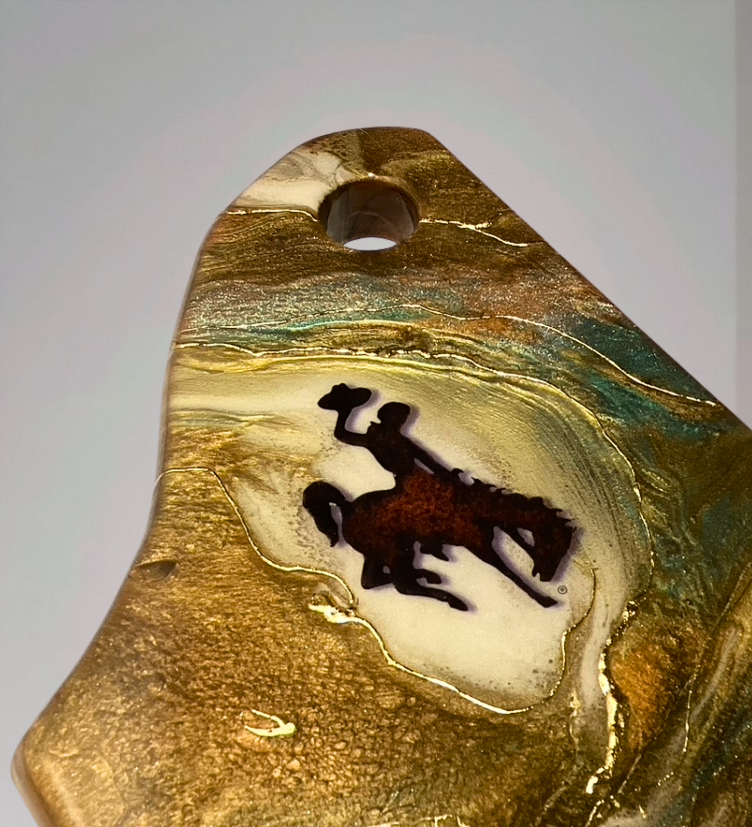 Handmade acacia wood charcuterie board with bucking horse design, resin art, and 24K gold accents inspired by Wyoming western heritage