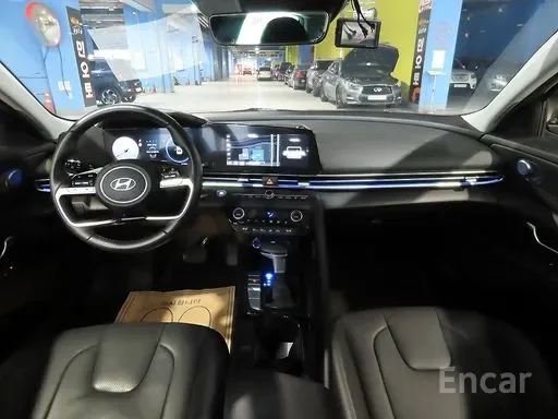 Interior of a Hyundai car showing the dashboard, steering wheel, and front seats inside a dealership or parking lot.
