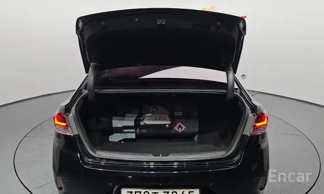 Open car trunk containing a gas cylinder with a warning label.