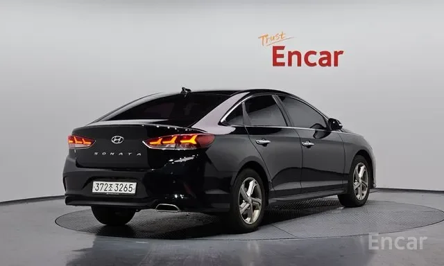 Black Hyundai Sonata in a gray showroom with 'Trust Encar' sign in the background.