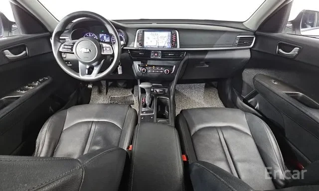 Front interior of a vehicle showing black leather front seats, dashboard with digital display, and steering wheel with controls.