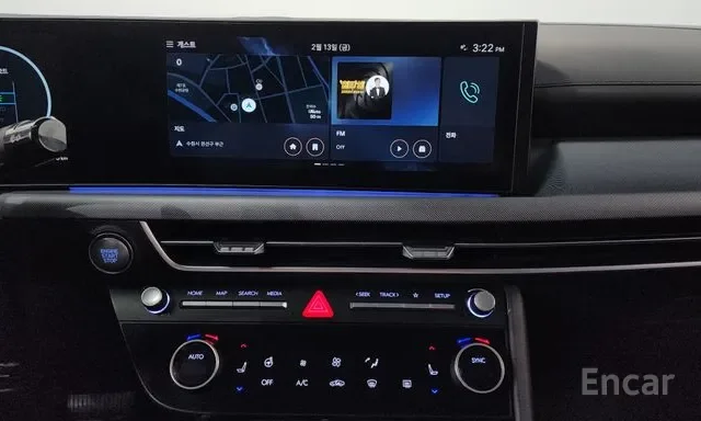 Car dashboard display screen showing navigation, radio, and time, with climate controls below.
