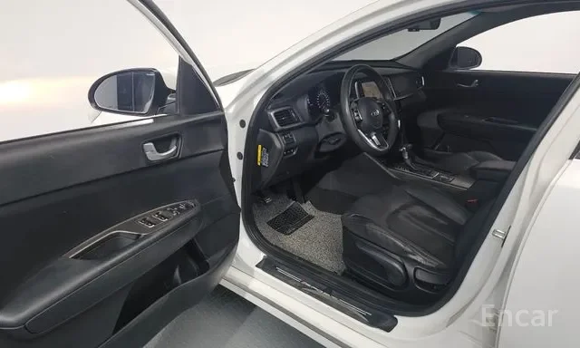 Interior of a modern black car with the driver's side door open, showing the steering wheel, dashboard, front seat, and door panel with window controls.