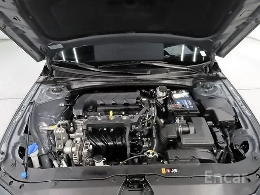 Under the hood of a car, showing the engine and various components.