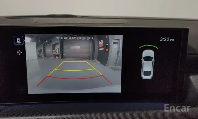 Car's backup camera display showing the parking space behind the vehicle with guiding lines, and a top-down view of the car with proximity sensors indicating distance.