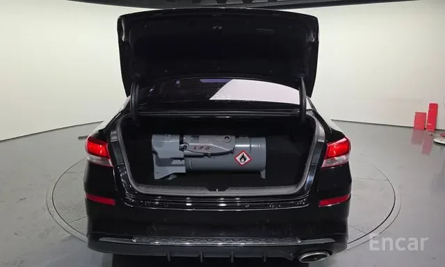 A black sedan with its trunk open, revealing a large bomb with a visible fuse inside the trunk.