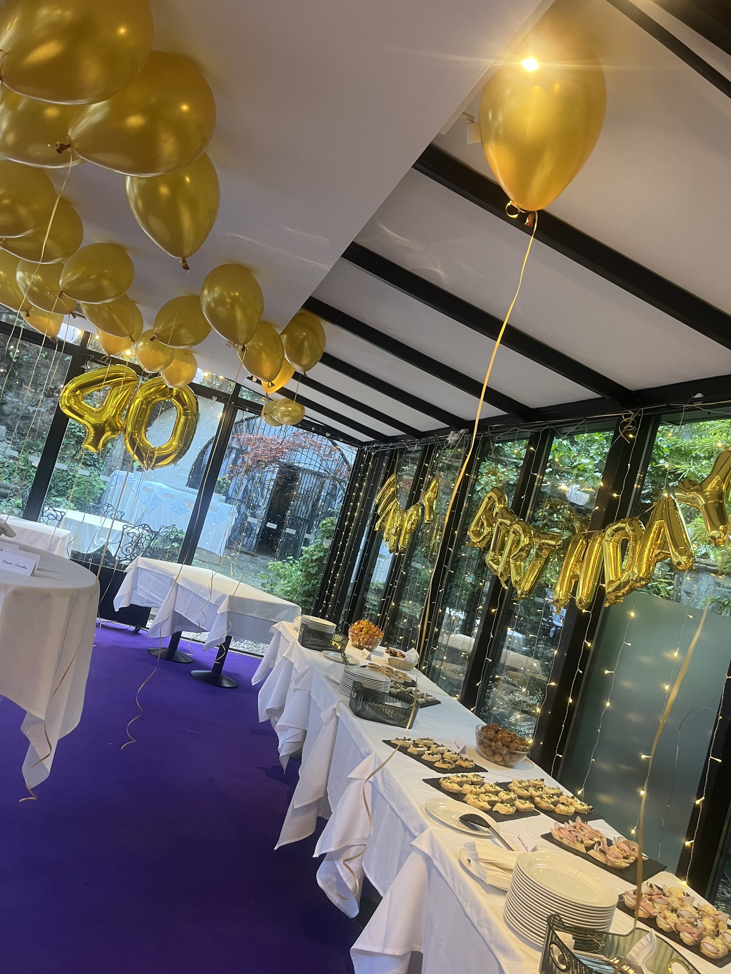 születésnapi dekorációval díszített üvegház belső tér kertre néző kilátással