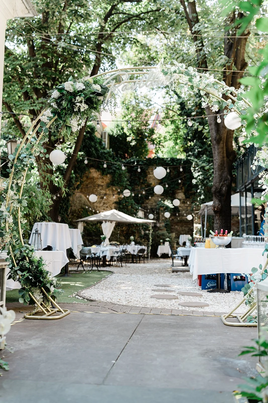 esküvői dekorral terített elegáns asztalok a kertben