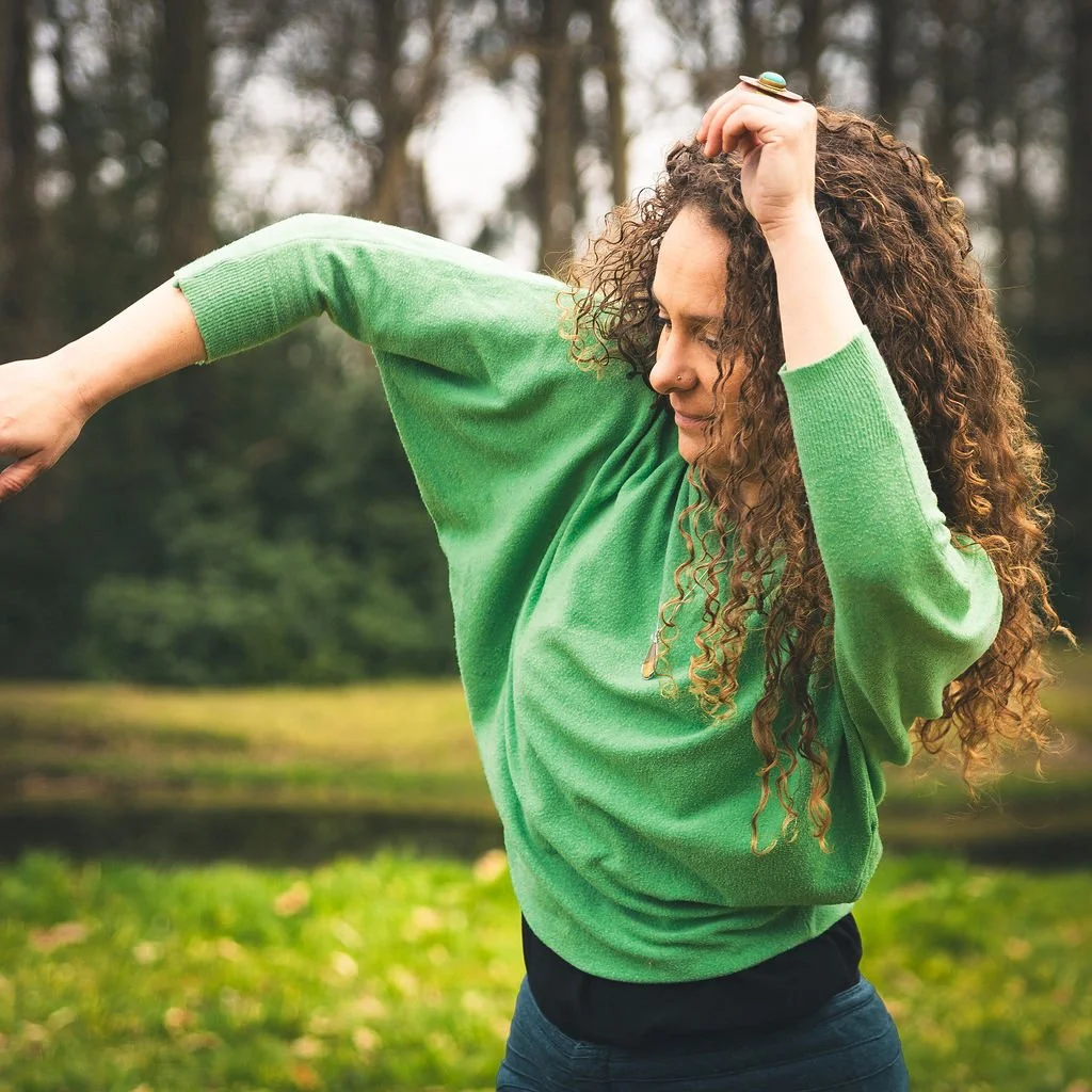 Vrouw die buiten in een groen shirt aan het bewegen is.