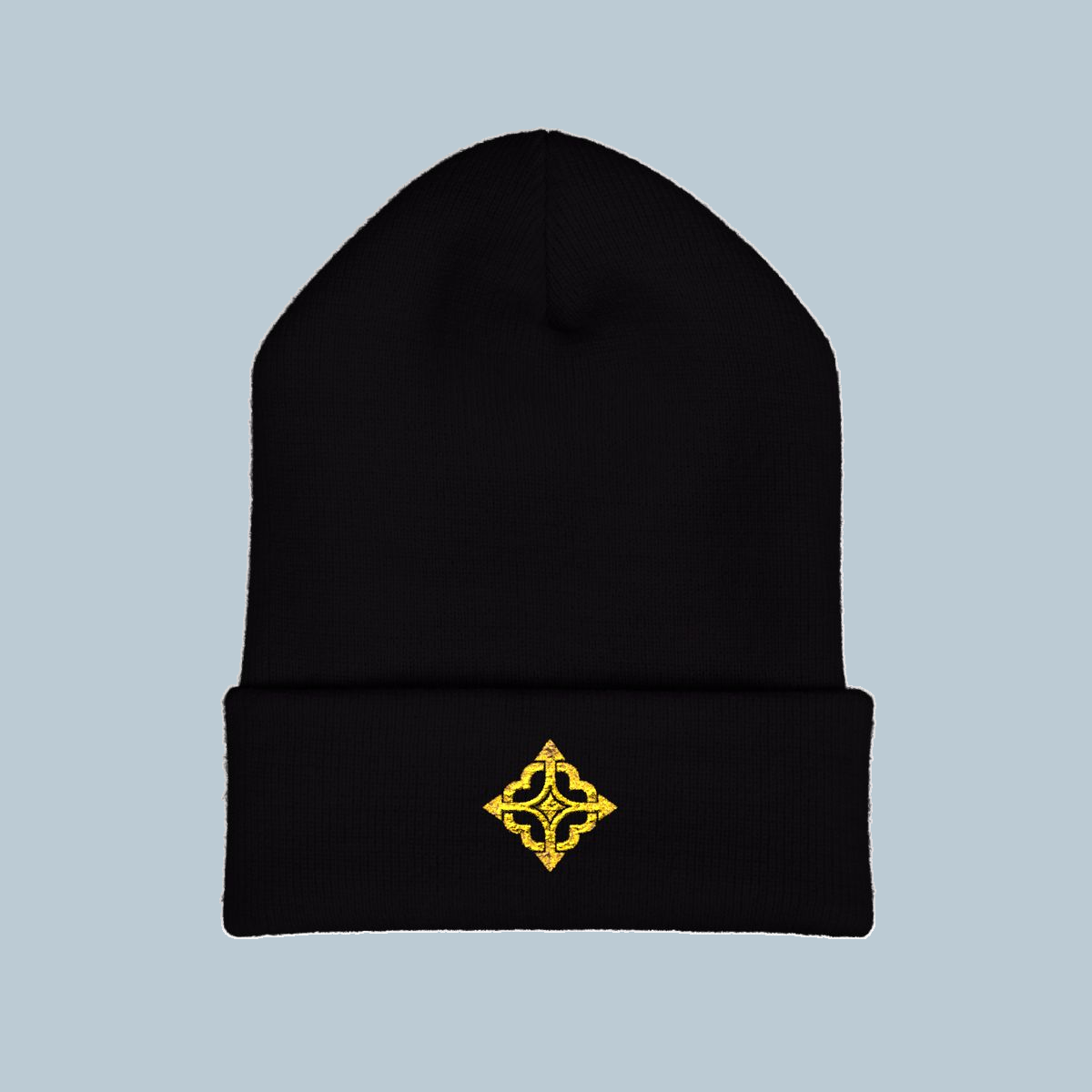 Black Yupoong 1501KC Quiet Compass beanie on cool blue-gray, original gold four-path compass embroidery on the front cuff.