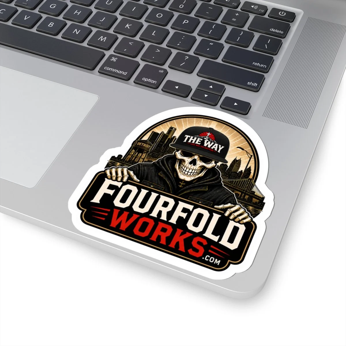 Fourfold Works skull logo sticker applied to a laptop palm rest.