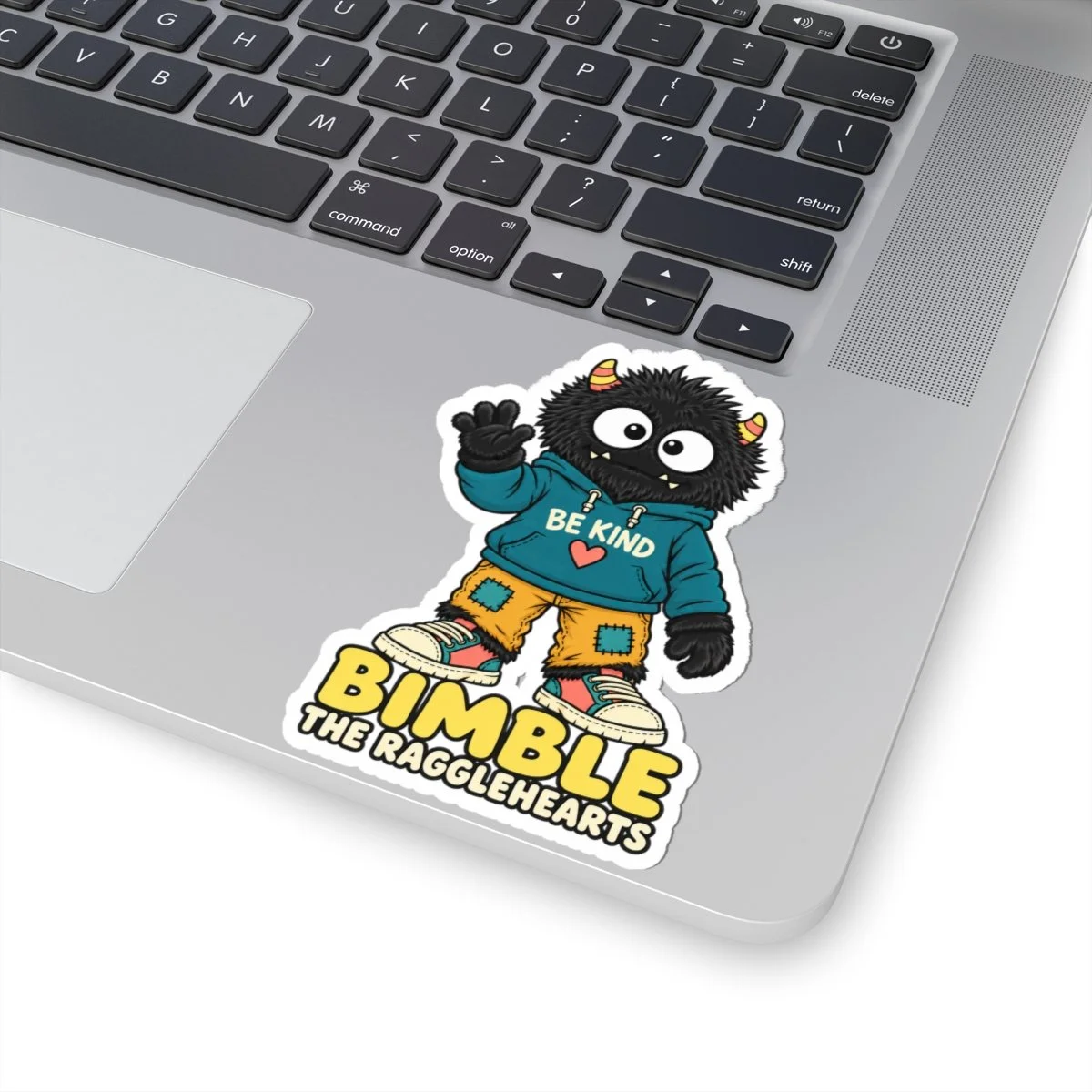 Black-furred Bimble Be Kind sticker applied to a laptop palm rest.