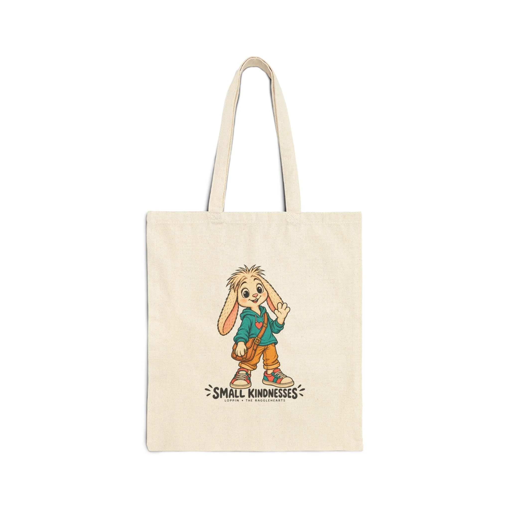 Front of the natural canvas Loppin tote, with the long-eared Ragglehearts character in a teal heart hoodie, tan satchel and Small Kindnesses lettering.
