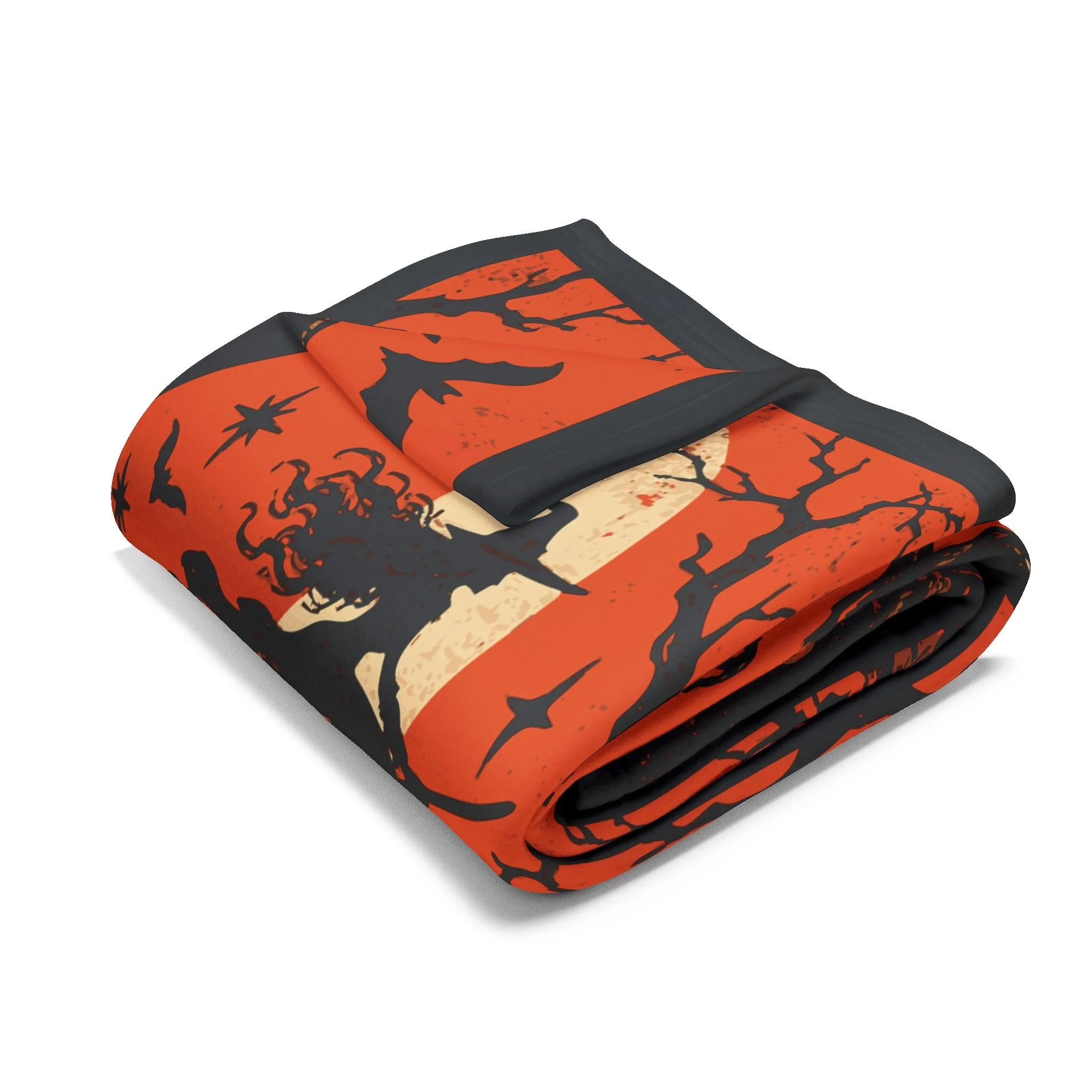 Folded Witching Hour fleece blanket showing orange and ivory print on a dark background.