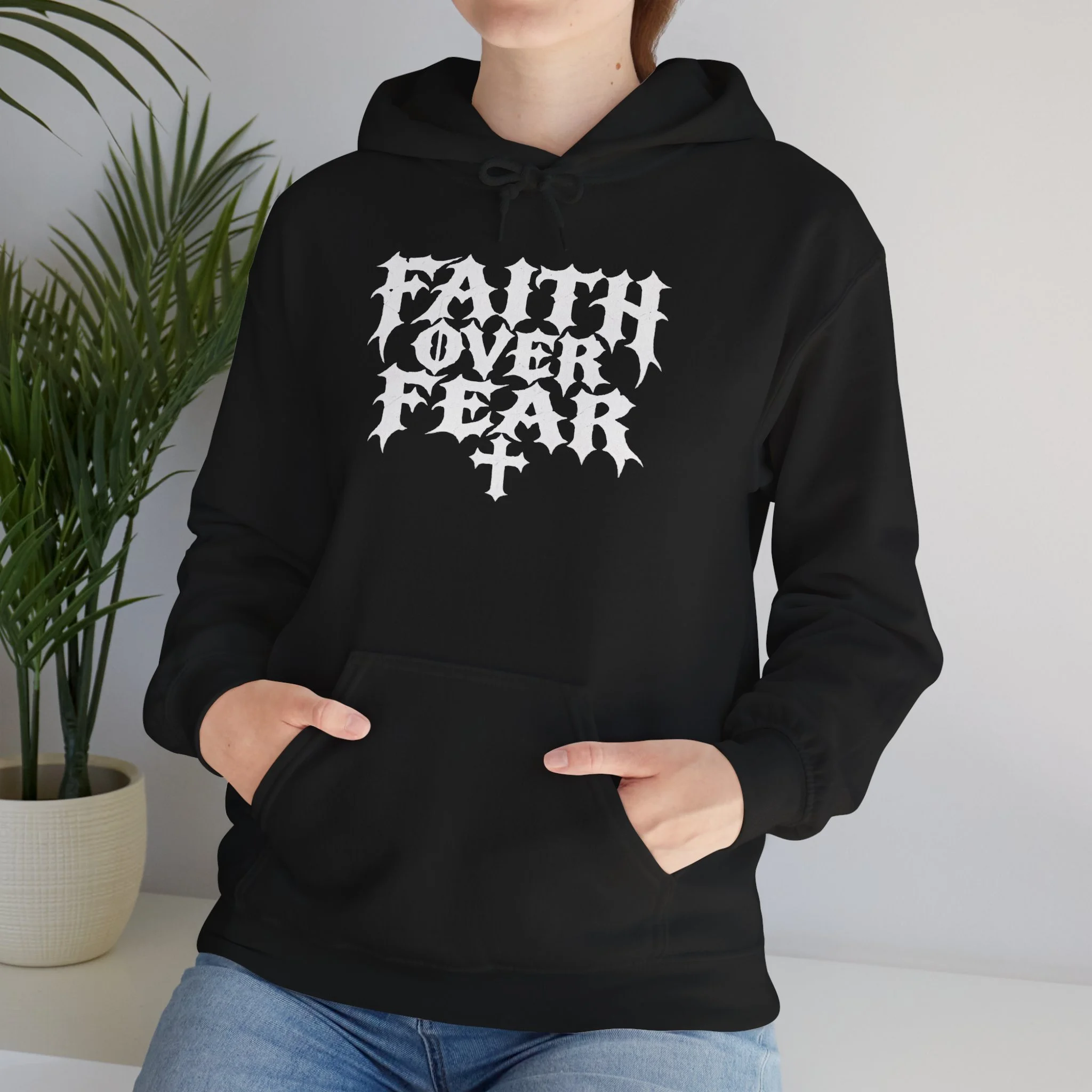 Model wearing Black Faith Over Fear hoodie with oversized distressed white gothic front lettering and cross