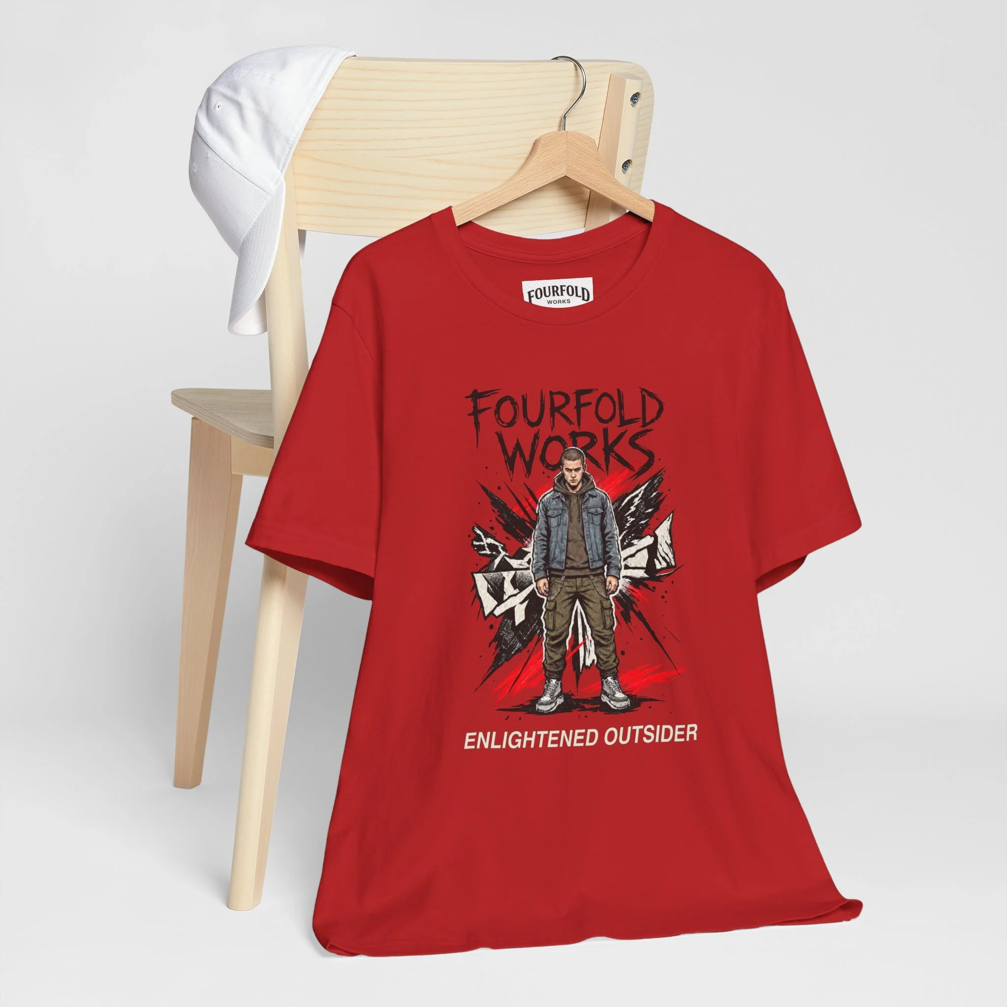 Red Enlightened Outsider Bella+Canvas 3001 T-shirt on a wooden hanger and chair, showing the approved original dark header and complete character artwork.