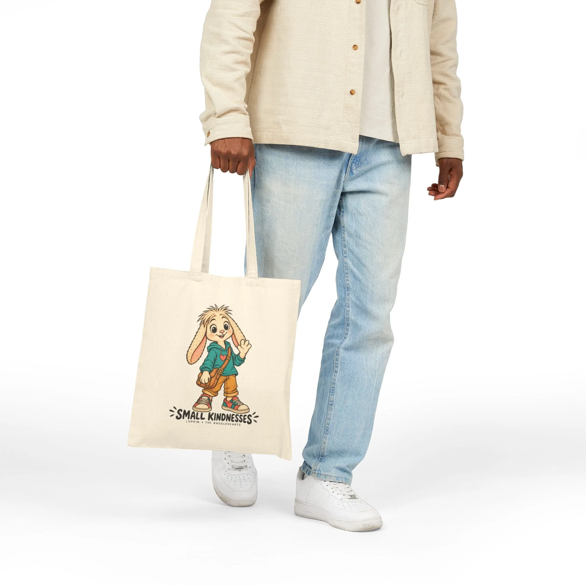 Natural Loppin canvas tote carried by hand, showing the printed front and full lettering.