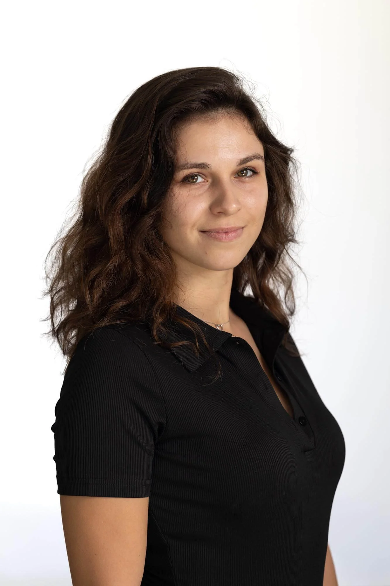 Professional headshot of a young woman in front of of white background.