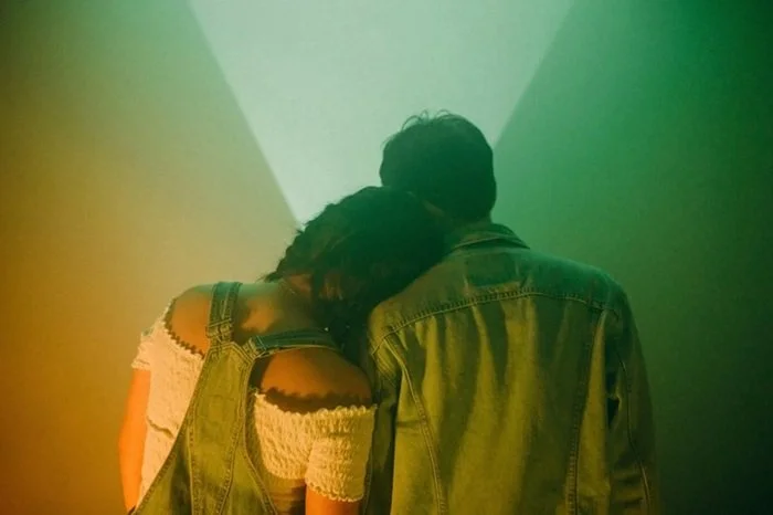 Woman resting her head on mans shoulder lovingly