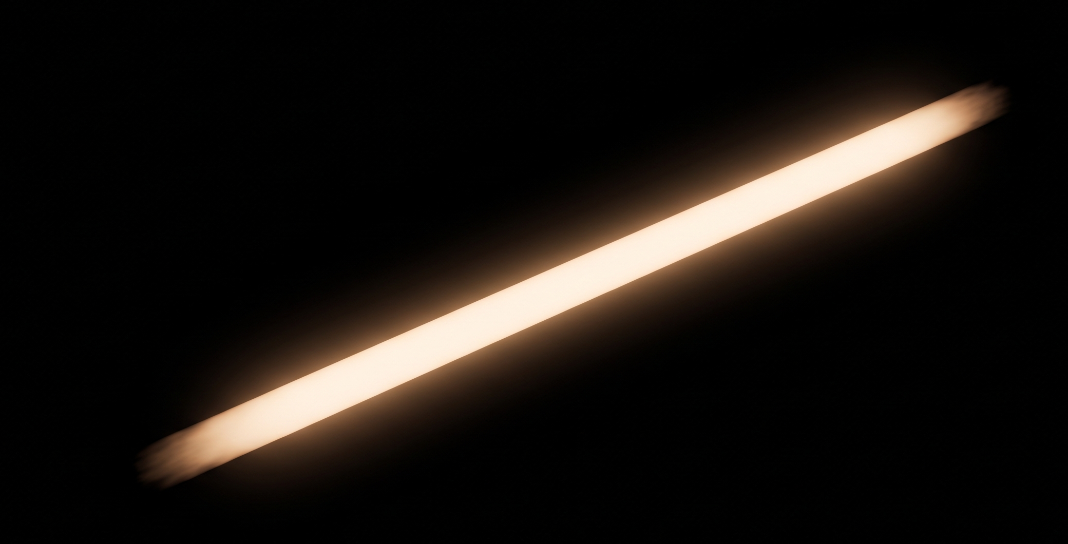 A diagonal bright, glowing light streak against a black background.