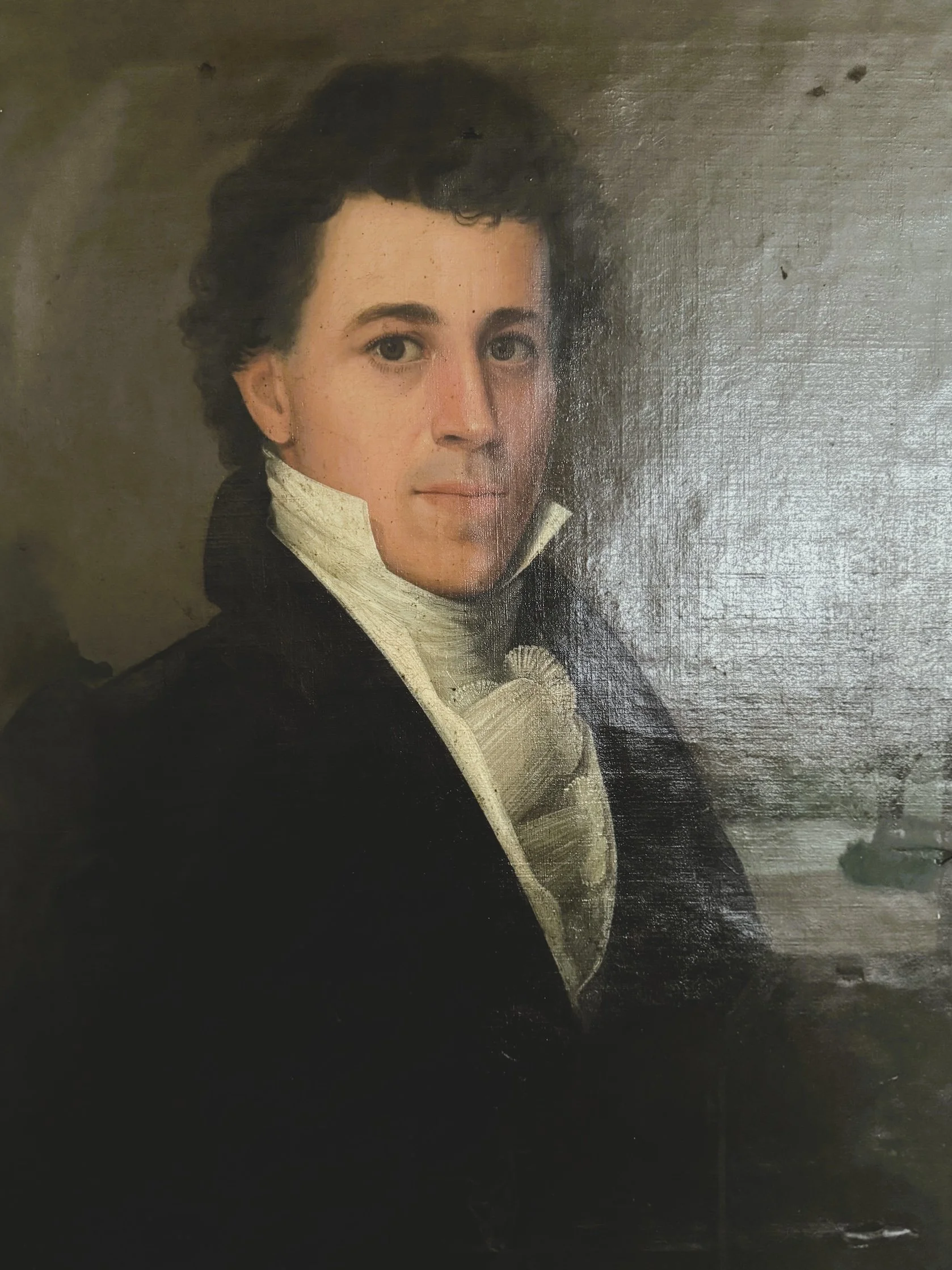 A portrait of a man with dark, curly hair, wearing period clothing with a high collar, set against a dark background.