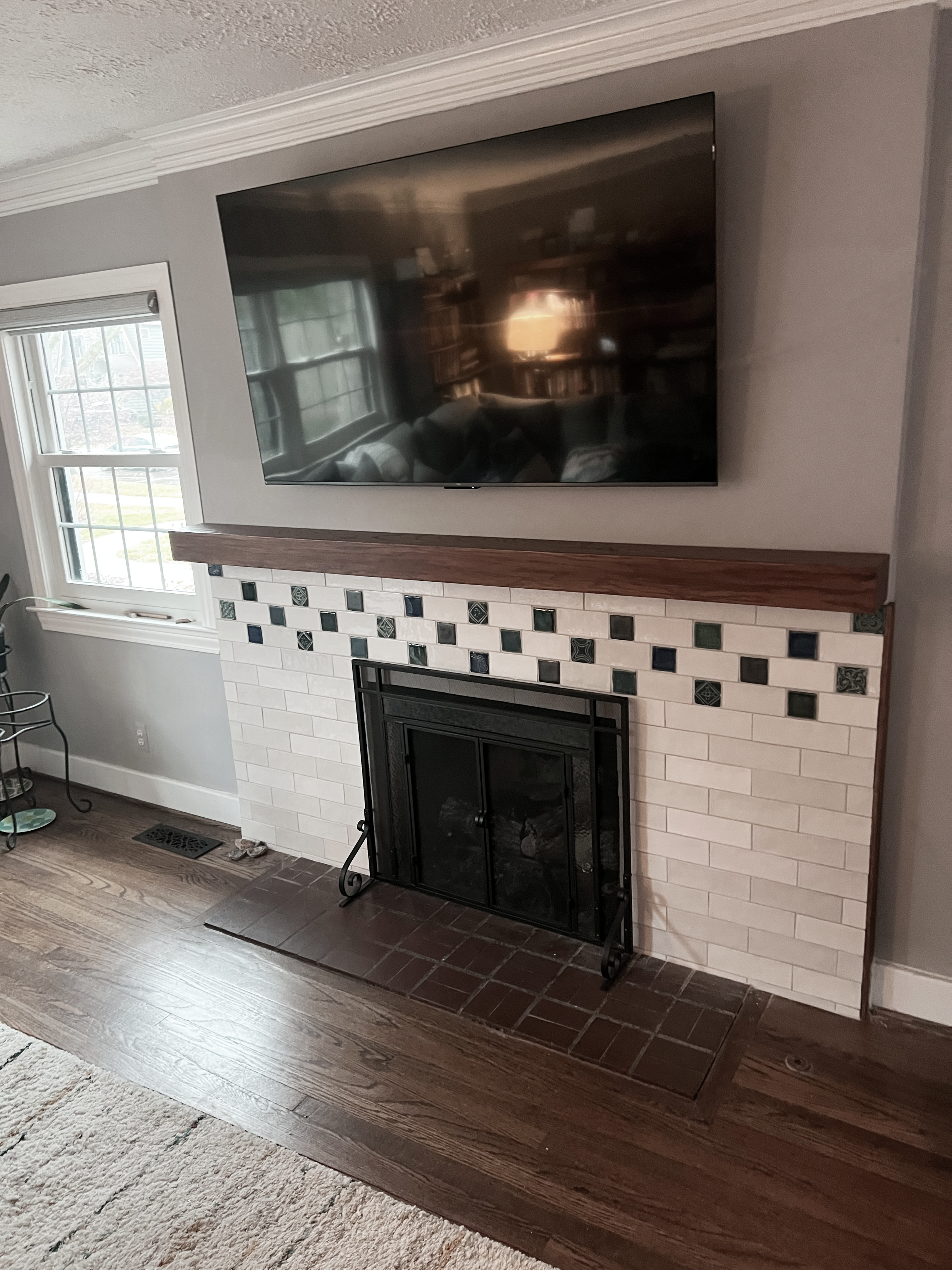 AFTER - New fireplace tile surround with Pewabic tiles inset. Custom red oak mantle with TV mount and hookup above.