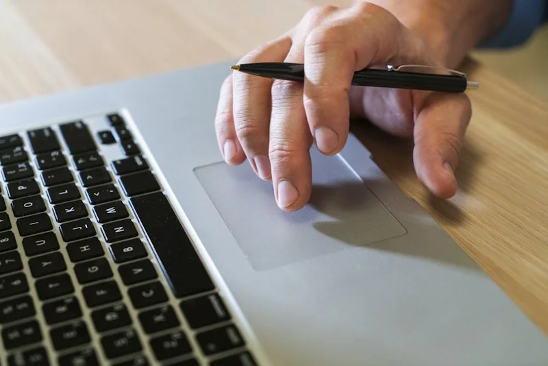 hand clicking trackpad on laptop