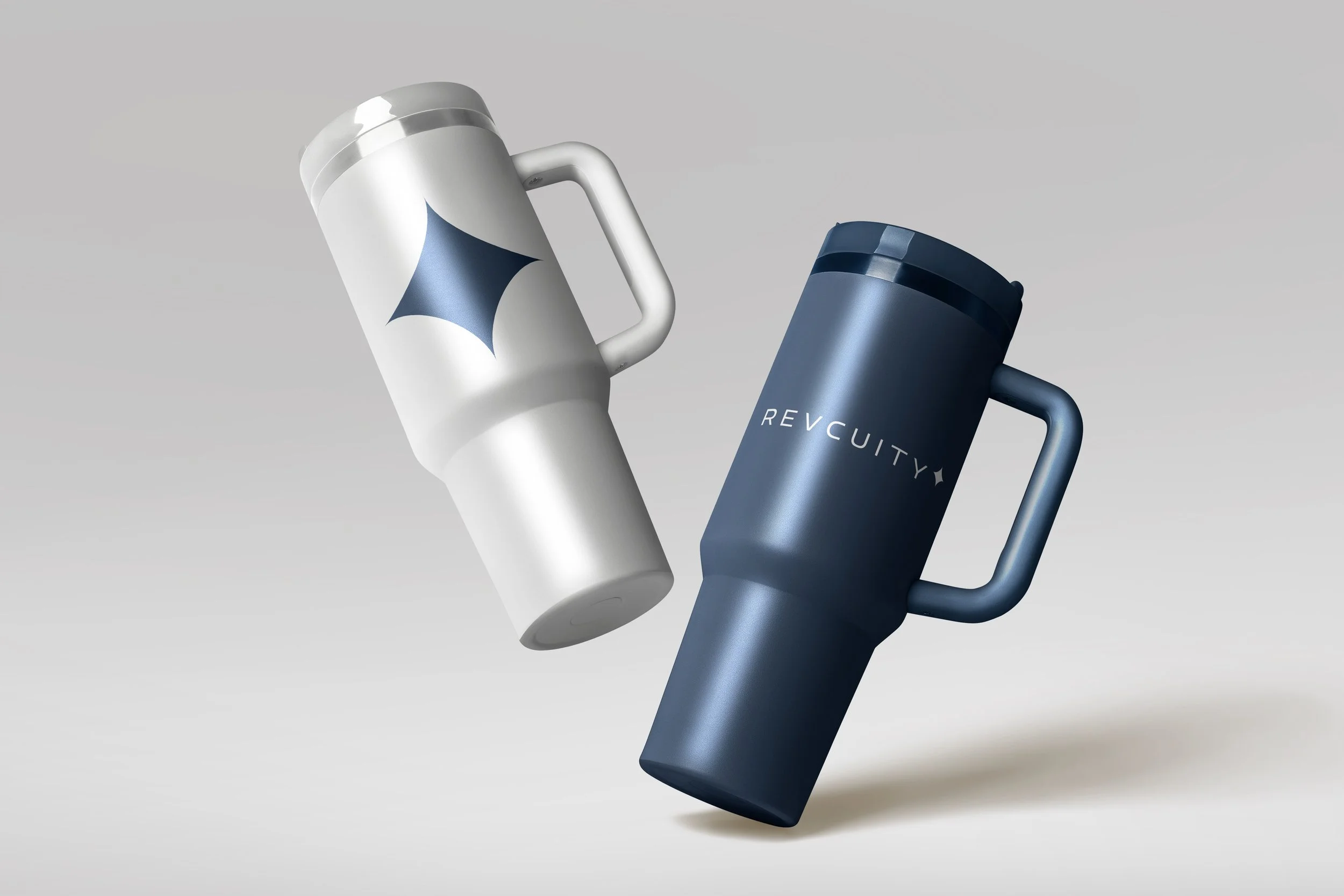 Two travel mugs, one white with a blue star design and the other dark blue with 