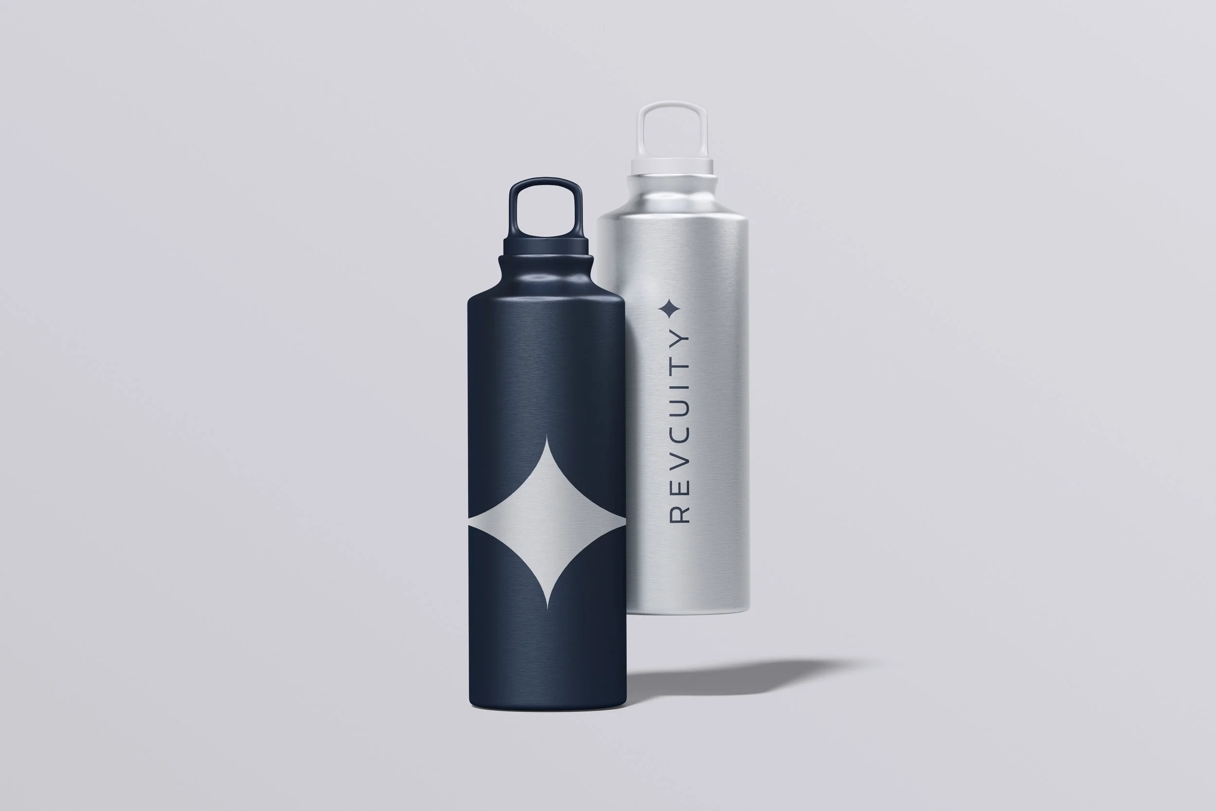Two metallic water bottles, one black with a white geometric star pattern and one silver with black text that says REVOCUITY, floating against a light gray background.