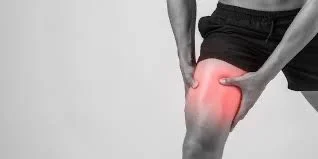 Person holding their knee with a red area indicating pain or injury.