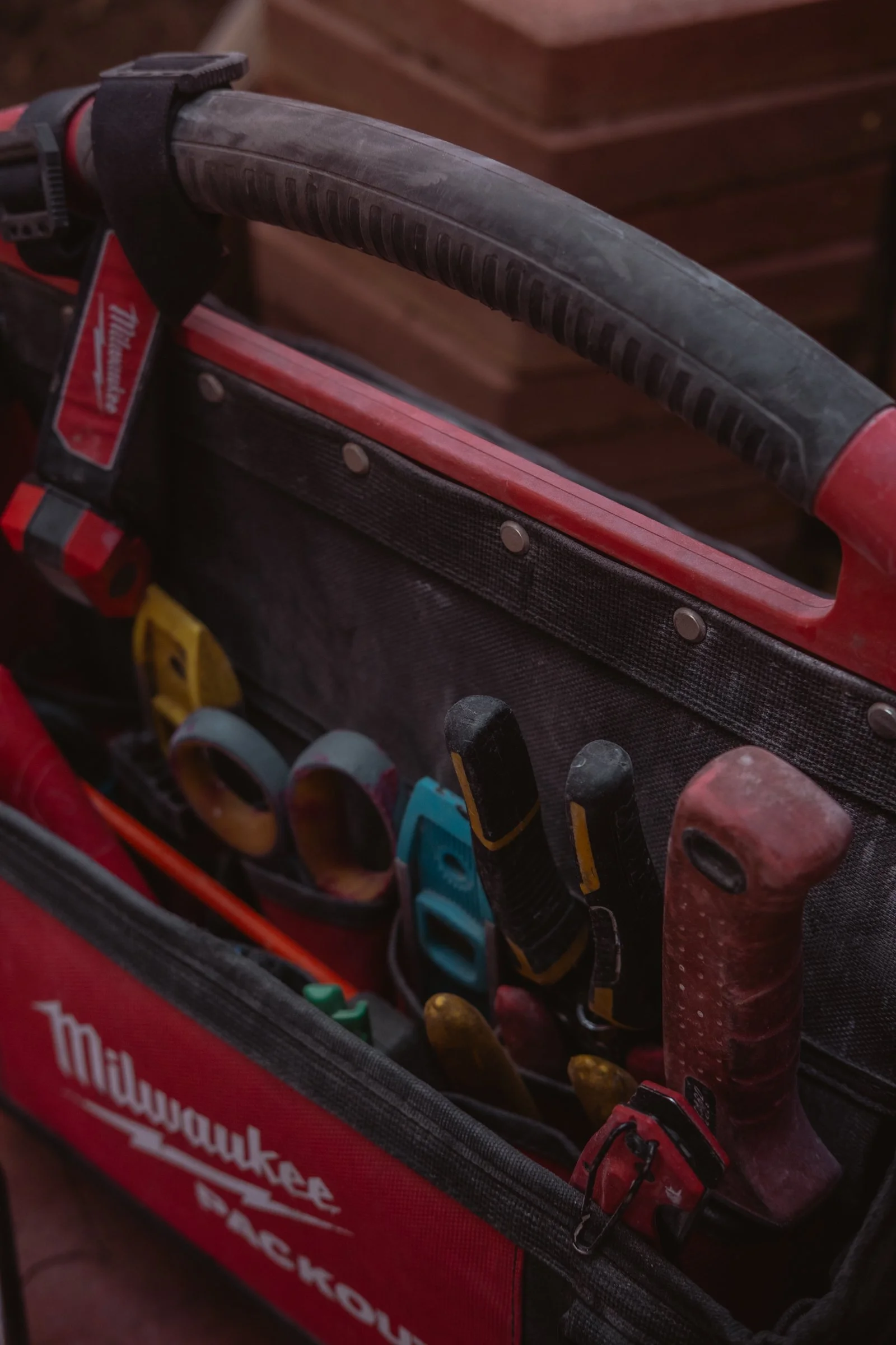 A red tool bag filled with various tools owned by Holda Handyman, a handyman and home renovator servicing Gilbert, Arizona and the Greater Phoenix Area.
