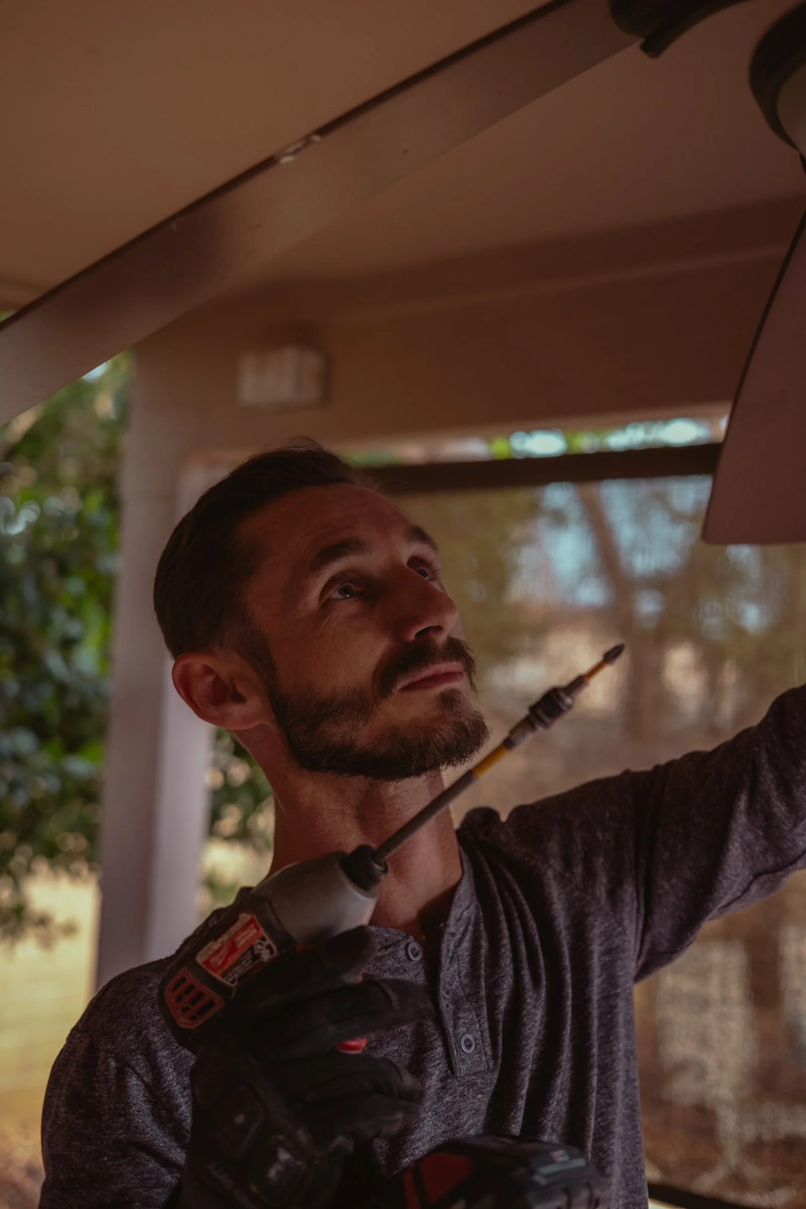 Mariusz Holda, owner of Holda Handyman, installing a ceiling fan for a home renovation client in Gilbert, Arizona.