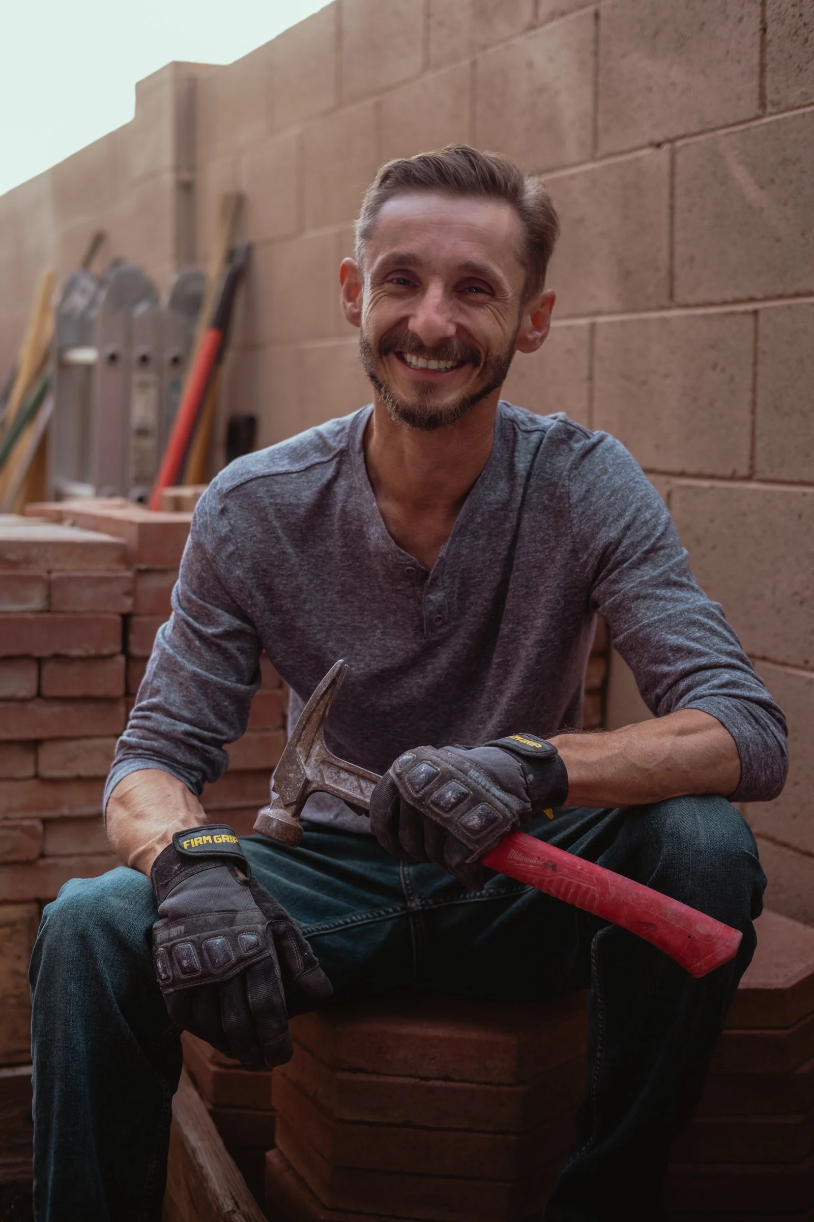 Mariusz Holda, owner of Holda Handyman, sitting and smiling with various power tools around him in the midst of a handyman home renovation project servicing the Greater Phoenix Area.